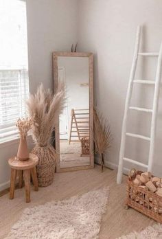 a ladder leaning up against a white wall next to a mirror and basket on the floor