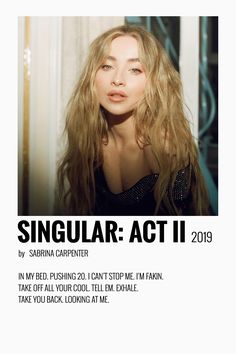 a woman with long blonde hair posing for the camera in front of a poster that says singular act ii