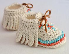 crocheted baby booties with tassels and bows on the toes are shown