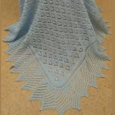 a blue crocheted blanket sitting on top of a floor