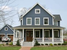 a blue house with white trim on the front porch