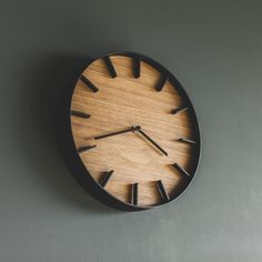 a wooden clock mounted to the side of a wall