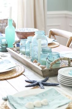 the table is set with plates and glass jars