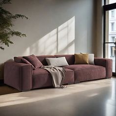 a living room filled with furniture next to a large window and a potted plant