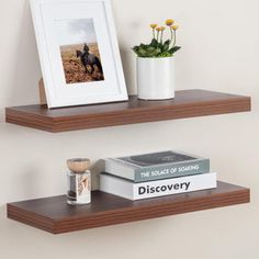 two wooden shelves with books and pictures on them, one has a framed photo next to the other