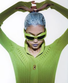 a woman with blue hair and green sweater