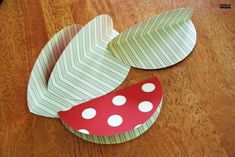 two paper plates sitting on top of a wooden table covered in polka dot dots and leaves