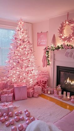 a pink christmas tree in a living room decorated for the holidays with presents under it