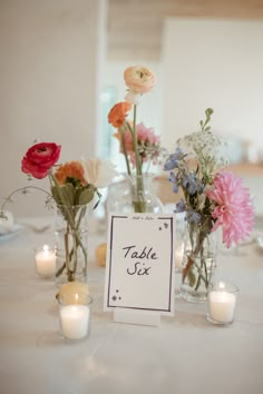 a table with flowers and candles on it