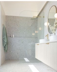 a bathroom with a sink, mirror and shower in it's center wall next to a walk - in shower