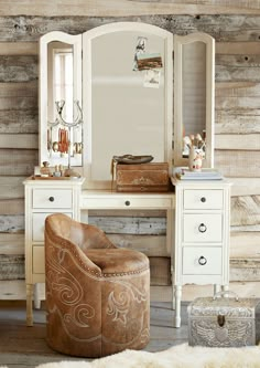 an old fashioned dressing table with a mirror, stool and ottoman in front of it