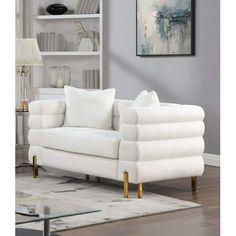 a living room with a white couch and some bookshelves on the wall behind it