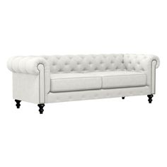 a white couch with black legs and buttons on the back, in front of a white background