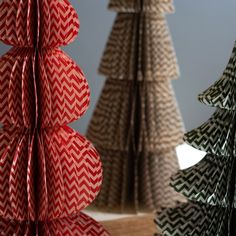 three paper christmas trees in different colors and sizes, one is folded to look like an origami tree