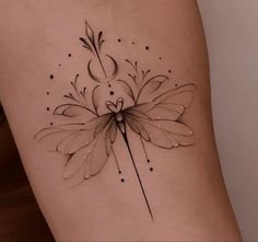 a woman's thigh with a flower tattoo on it and an arrow in the center