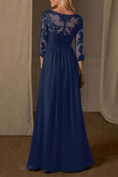 a woman wearing a long blue dress with sheer sleeves and lace detailing on the shoulders