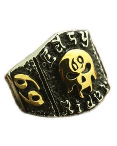 a gold and silver ring with two skulls on the front, one in the middle