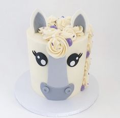 a white cake decorated with a horse's head and flowers