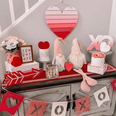 a valentine's day table with bunting, cake and decorations on the top