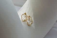 Artsy and modern, this pair features wavy golden frames housing freshwater pearls reminiscent of oysters. Dimensions: 12 mm x 15 mm (approx. 0.47 in x 0.59 in) Materials used (pictured): 14K solid yellow gold, 0.75 g2 x freshwater pearls, 4 mm Elegant Gold Pearl Earrings With Polished Finish, Wavy Yellow Gold Jewelry For Formal Occasions, Formal Yellow Gold Wavy Jewelry, Elegant White Gold Wavy Jewelry, Elegant Wavy White Gold Jewelry, Oval Akoya Pearl Gold Jewelry, Gold Pearl Earrings Tarnish Resistant, Gold Oval Pearl Earrings Fine Jewelry, Gold Oval Pearl Earrings In 14k