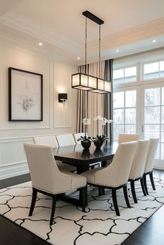 a dining room table with white chairs and a chandelier hanging from the ceiling