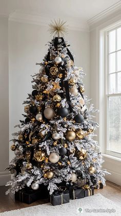 a white christmas tree with black and gold ornaments