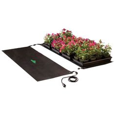 a black mat with pink flowers in it and a power cord attached to the ground