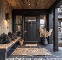 the front porch is decorated with black and wood accents, including two benches and a door