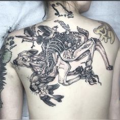 the back of a woman's body with tattoos on it