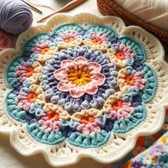 a crocheted doily is sitting on a table next to some knitting supplies