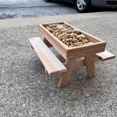 a wooden bench with rocks in it on the ground