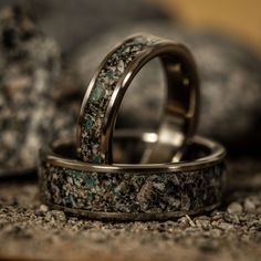 two wedding rings with green and black marble inlays on top of each other