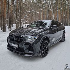 the bmw x4 is driving on a snowy road