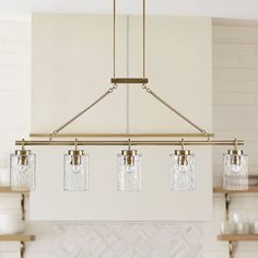 a kitchen light hanging from the ceiling over a stove top with glass jars on it