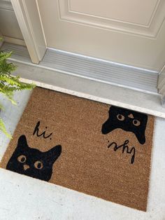 a door mat with two black cats on it