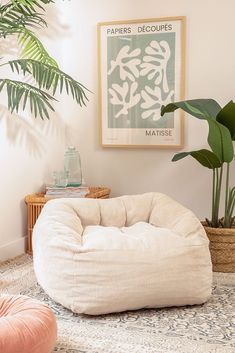 a bean bag chair sitting on top of a rug next to a potted plant