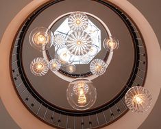 a circular chandelier hanging from the ceiling in a room with round glass lights