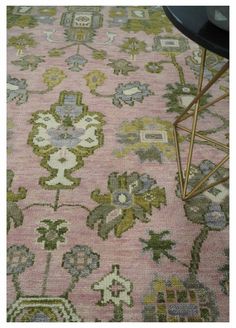 a pink rug with green and yellow flowers on it