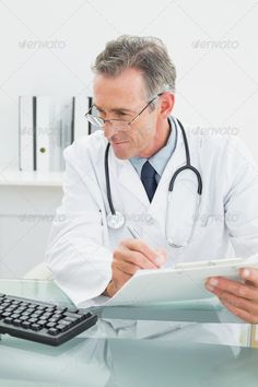 a male doctor in white coat and glasses is looking at papers