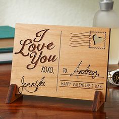 a wooden sign that says i love you on it next to some books and an alarm clock