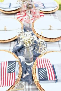 the table is set with plates and place settings for an american flag themed dinner party