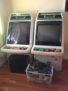 two old fashioned video games sitting on top of a wooden floor next to each other