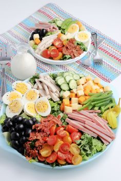 two plates filled with different types of food on top of a blue and white table cloth