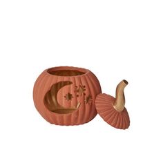 an orange pumpkin shaped candle holder with a carved moon and star design on the front