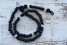 Prepare to embark on a sacred journey of unwavering devotion with our "Solemn Crusader" Paracord Rosary. Crafted for those who seek both strength and grace in their faith, this rosary is a symbol of profound reverence and militant devotion. The "Solemn Crusader" Paracord Rosary is shrouded in solemnity. Its black paracord, as dark as the midnight vigil of a crusader, forms a durable and sturdy foundation, ready to withstand life's challenges. The 12mm shiny black Hail Mary beads exude strength, Adjustable Spiritual Rosary With Miraculous Medal, Adjustable Rosary With Miraculous Medal And Crucifix, Spiritual Crucifix Rosary For Blessing, Paracord Rosary, Spiritual Warrior, St Benedict, Our Father, Hail Mary, Crusades