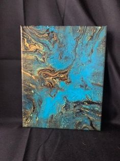 a blue and gold painting on a black background