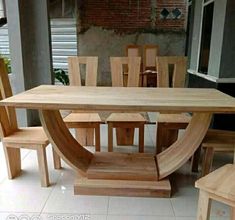 a wooden table and chairs in a room with white tile flooring next to a brick wall