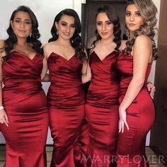 three women in red dresses standing next to each other with one woman wearing a long dress