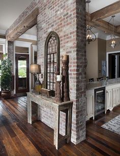 a living room with a brick wall and wooden floors