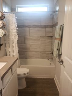 a bathroom with a toilet, sink and bathtub next to a shower curtain in it